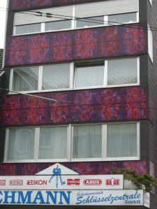 Grafisch gemusterte blau-rote KerAion-Platten an der Hausfassade auf der Hauptstraße 172 in Frechen